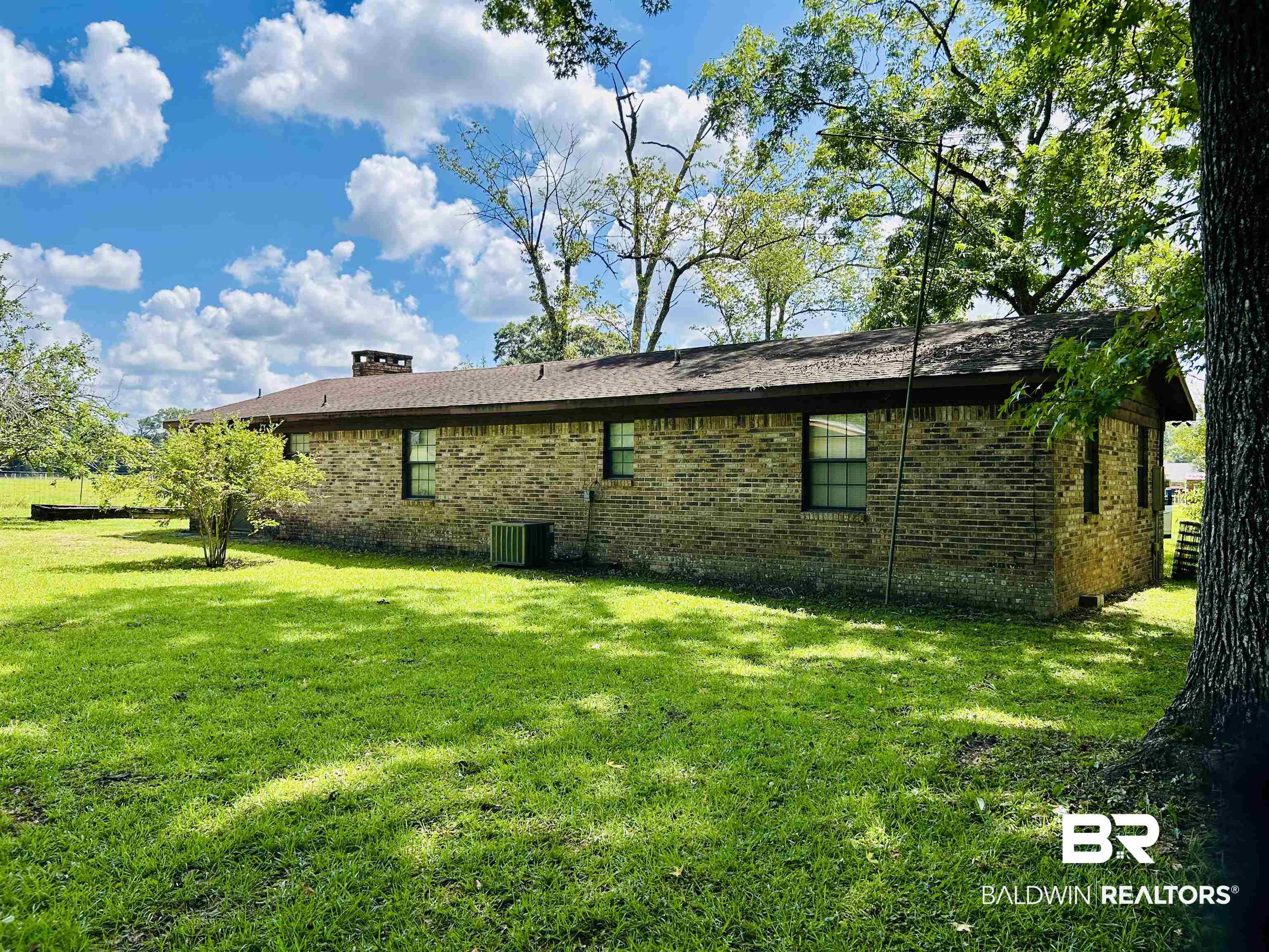 1350 A Schillinger Road South Mobile, AL 36695 - Photo 17 of 18 View of home's exterior with brick siding and a yard