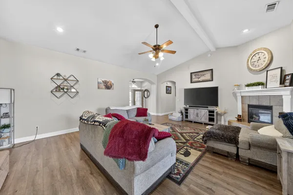 a living room with furniture a flat screen tv and a fireplace