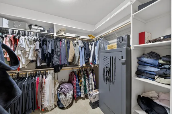 a view of walk in closet with clothes and shoes