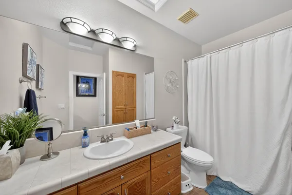 a bathroom with a granite countertop sink a toilet and mirror