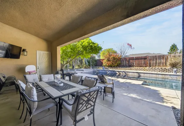 a view of an outdoor dining space with a table and chairs