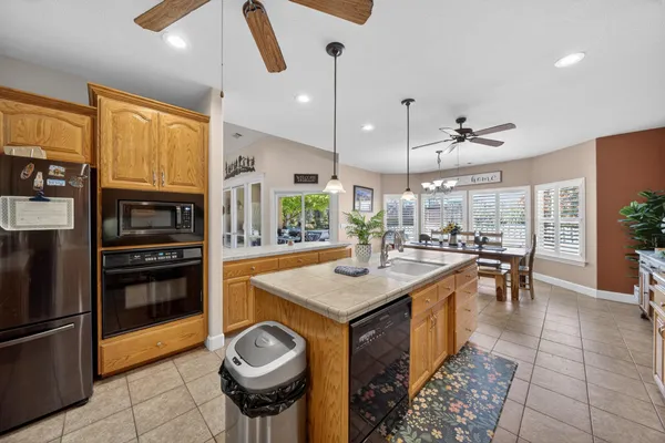 a kitchen with stainless steel appliances granite countertop a sink a stove and a refrigerator