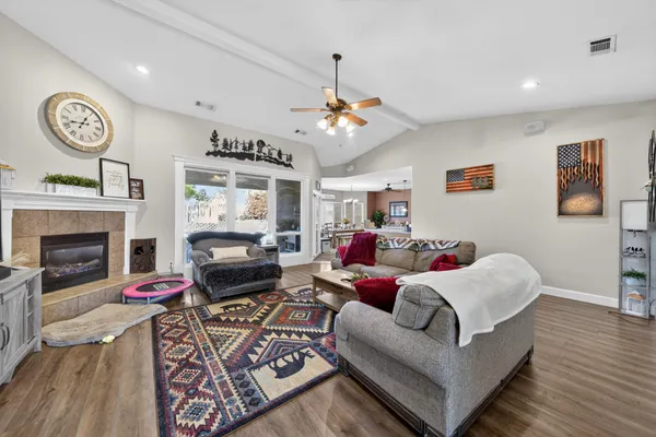 a living room with furniture a fireplace and wooden floor