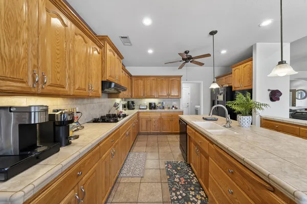 a large kitchen with stainless steel appliances lots of counter space and a sink