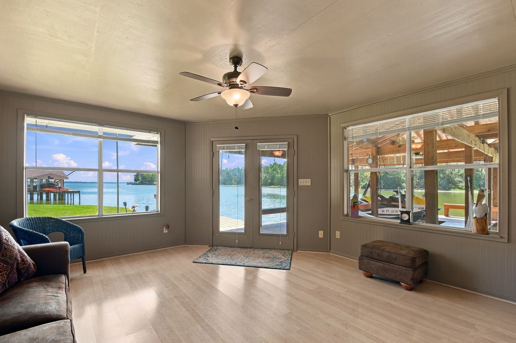 20341 Bay Hill Road Point Blank, TX 77364 - Photo 44 of 50 Radiant living space with large windows offering stunning waterfront views and direct access to a serene outdoor deck.
