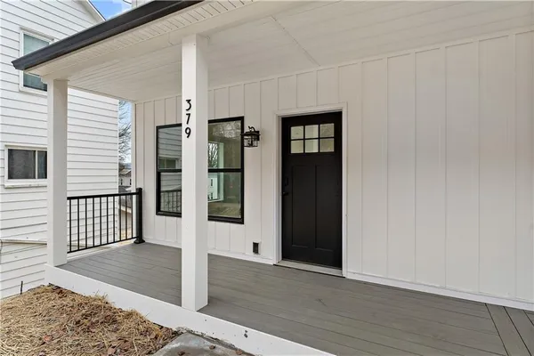 a view of a hallway with wooden floor and entryway