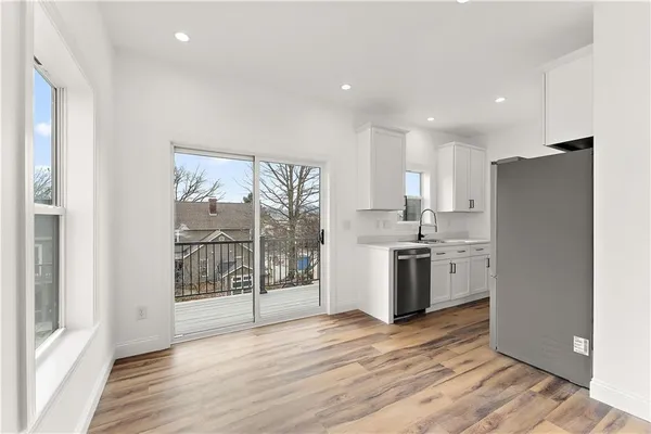 a kitchen with a refrigerator and wooden floor