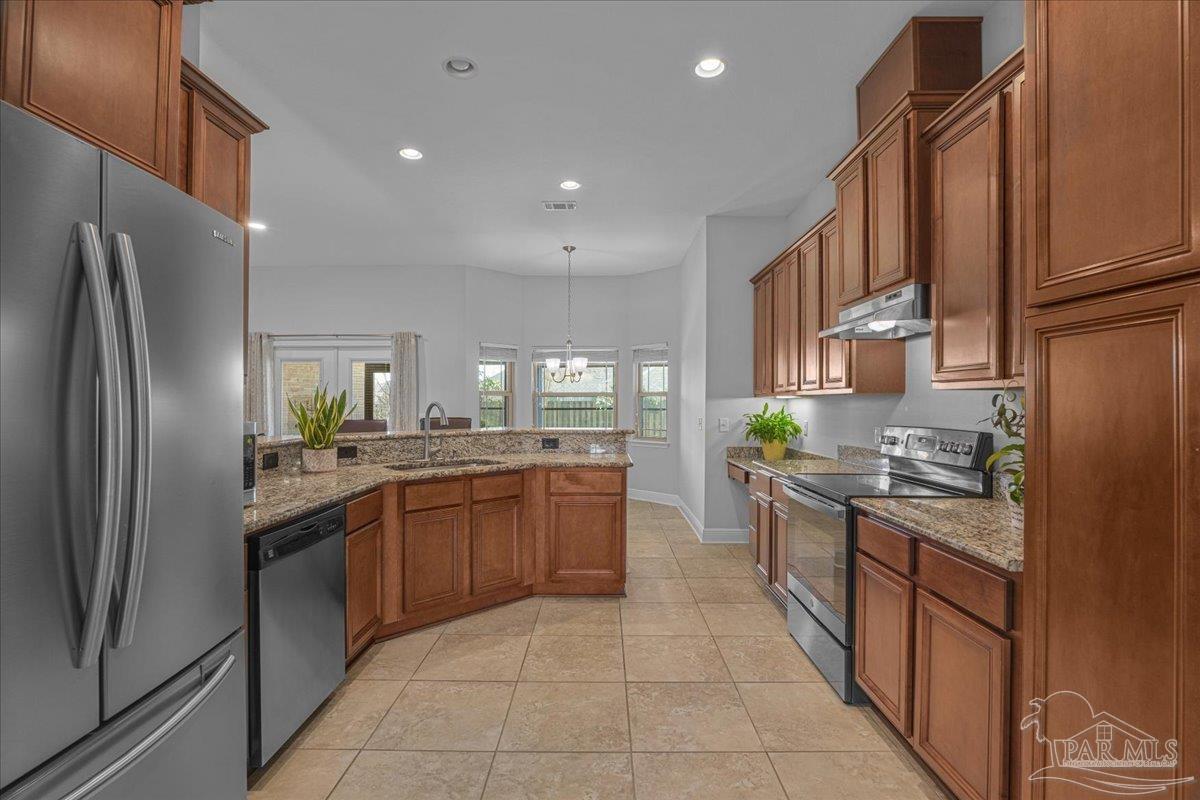 5997 Stonechase Boulevard Pace, FL 32571 - Photo 13 of 52 a kitchen with stainless steel appliances granite countertop a refrigerator a stove and a sink