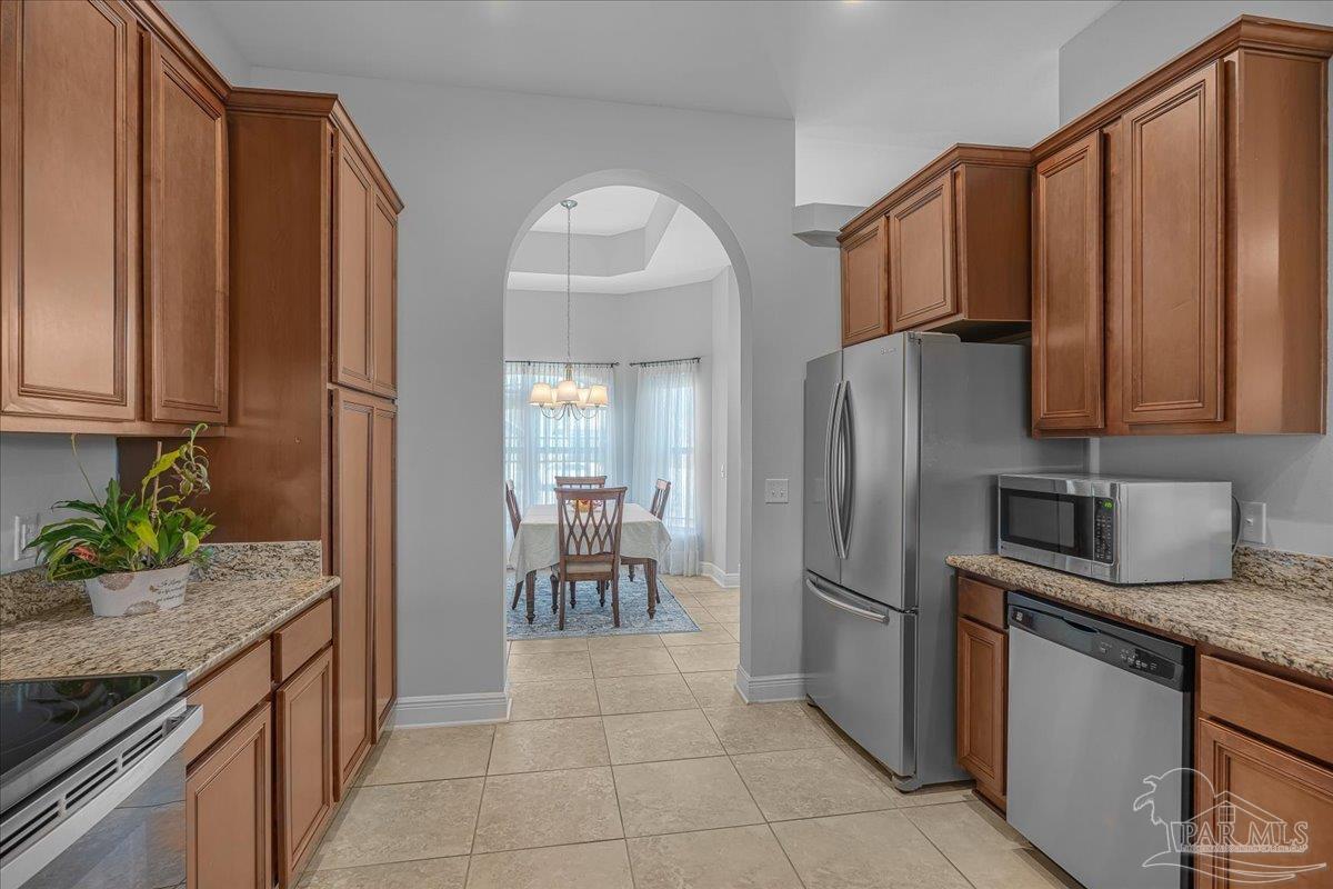 5997 Stonechase Boulevard Pace, FL 32571 - Photo 16 of 52 a kitchen with granite countertop a refrigerator and a sink