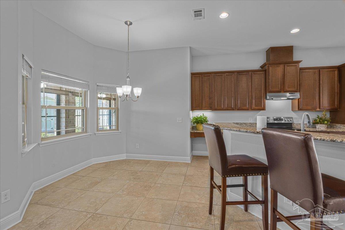 5997 Stonechase Boulevard Pace, FL 32571 - Photo 18 of 52 a kitchen with kitchen island granite countertop wooden cabinets and counter space
