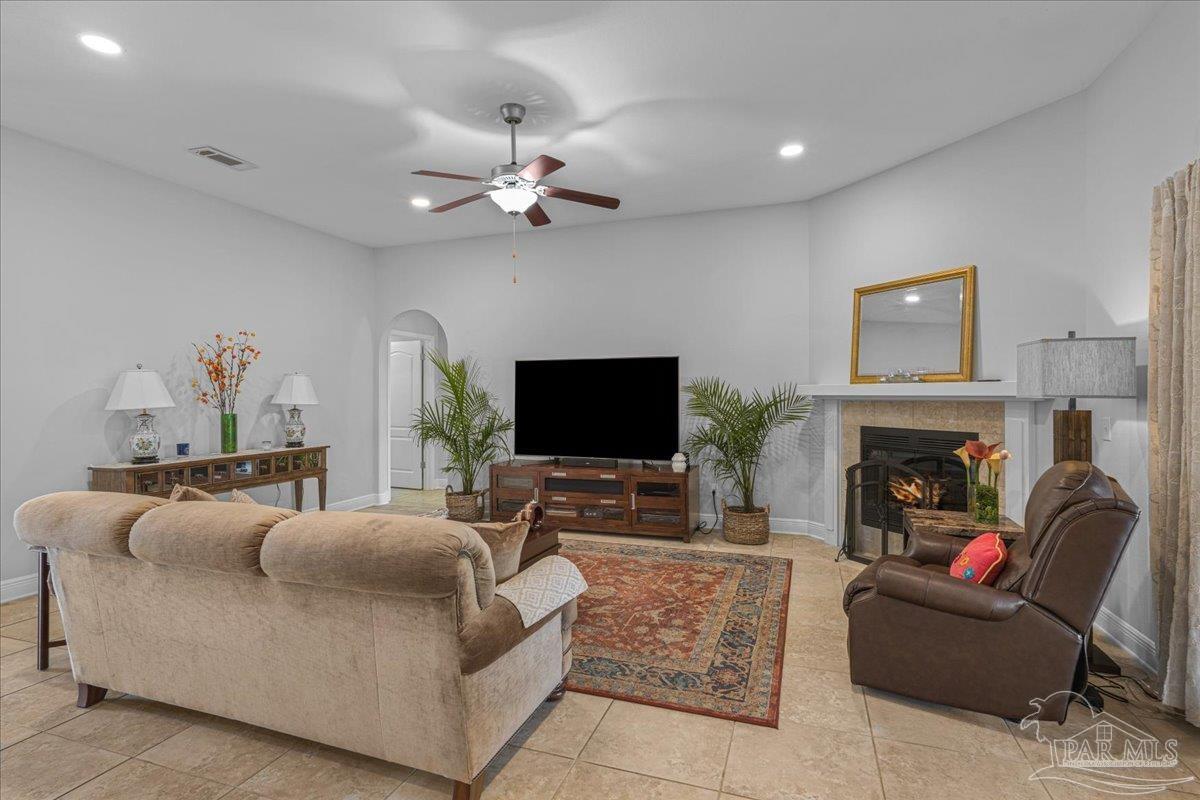 5997 Stonechase Boulevard Pace, FL 32571 - Photo 20 of 52 a living room with furniture a fireplace and a flat screen tv