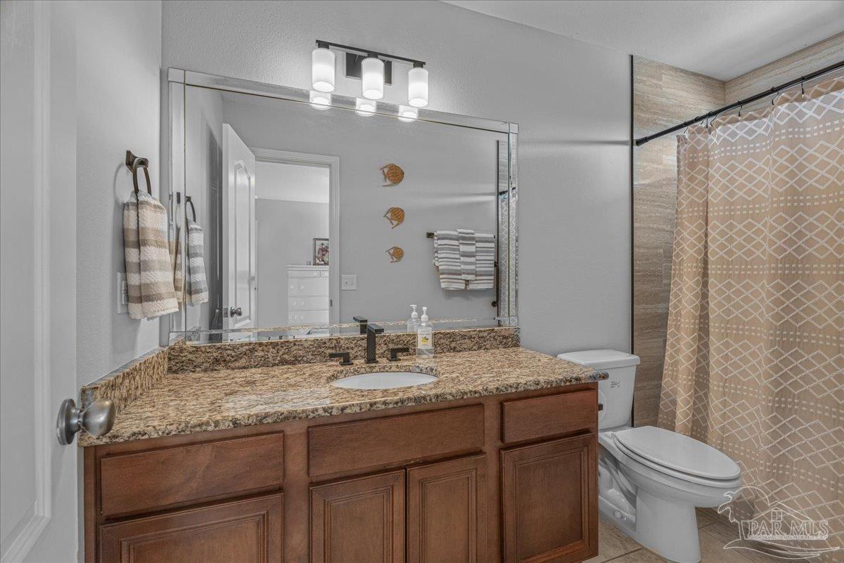 5997 Stonechase Boulevard Pace, FL 32571 - Photo 26 of 52 a bathroom with a granite countertop sink toilet and shower
