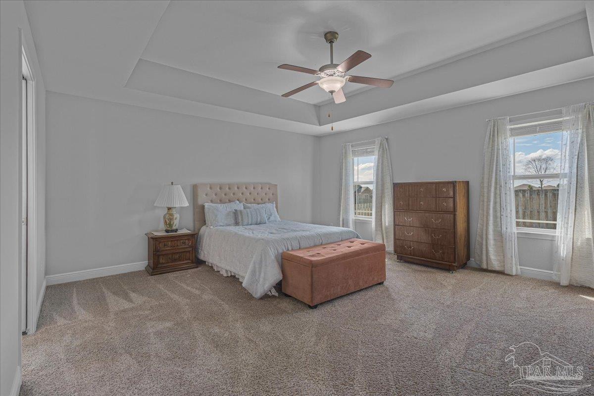 5997 Stonechase Boulevard Pace, FL 32571 - Photo 27 of 52 a spacious bedroom with a bed and a chandelier