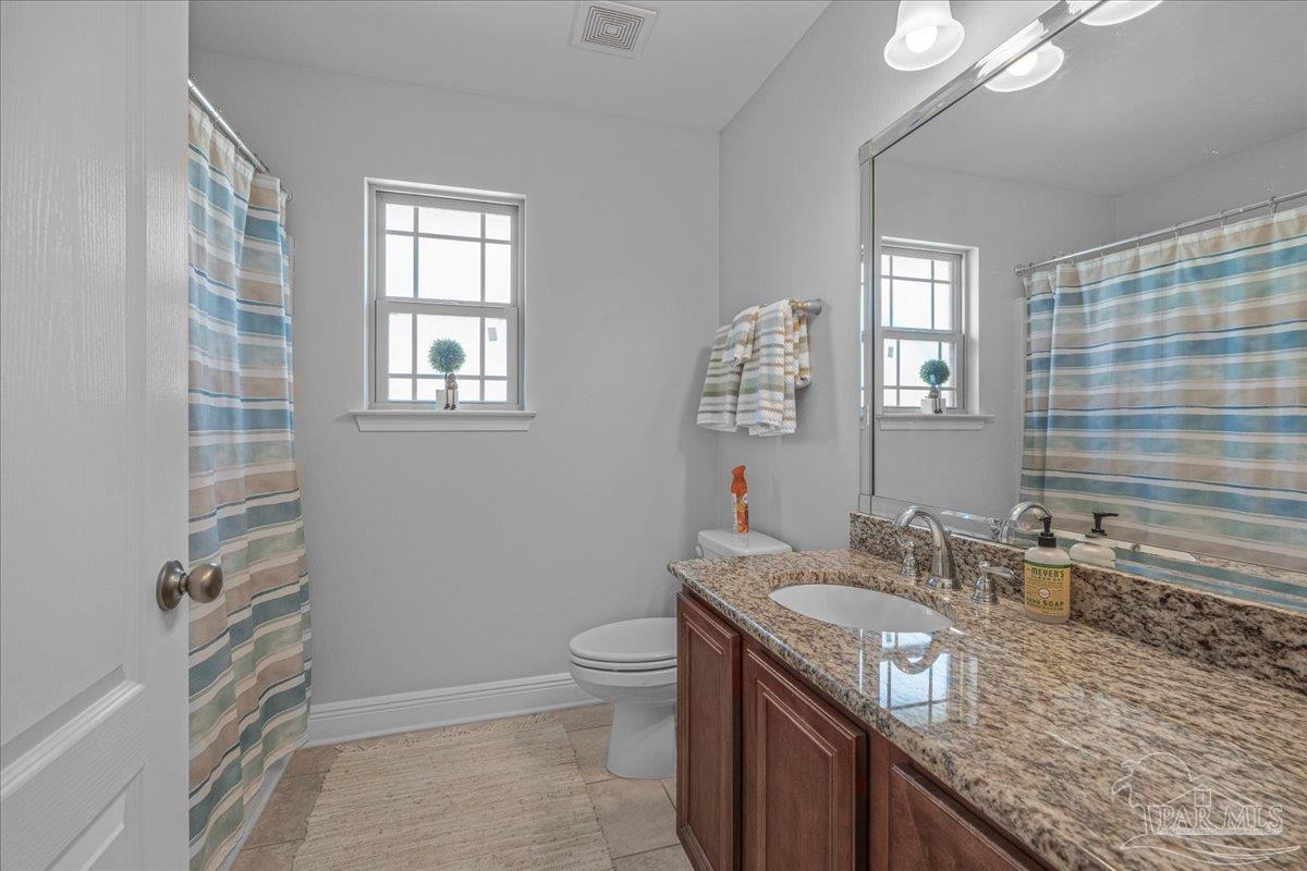 5997 Stonechase Boulevard Pace, FL 32571 - Photo 37 of 52 a bathroom with a granite countertop sink a toilet a mirror and shower