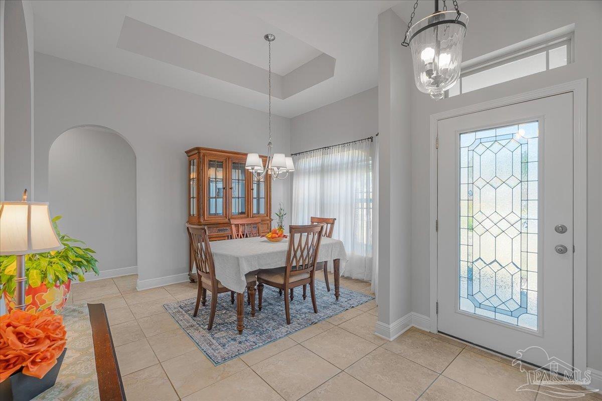 5997 Stonechase Boulevard Pace, FL 32571 - Photo 8 of 52 a dining room with furniture a chandelier and wooden floor
