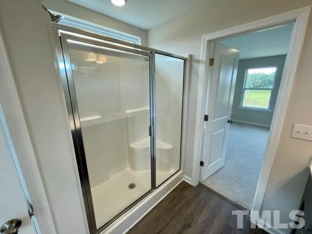 a bathroom with a glass door shower and a mirror