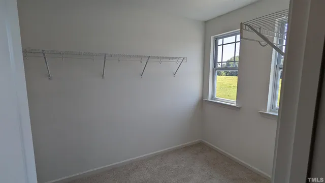 a view of an empty room with a window and a bathroom