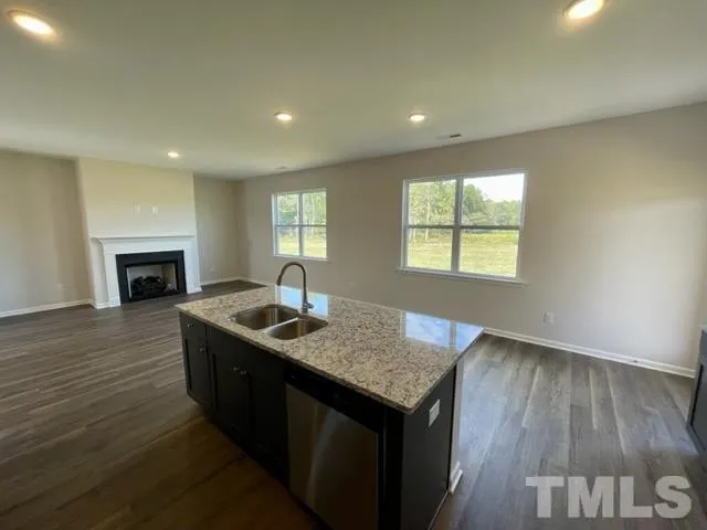 an open kitchen with granite countertop sink and cabinets