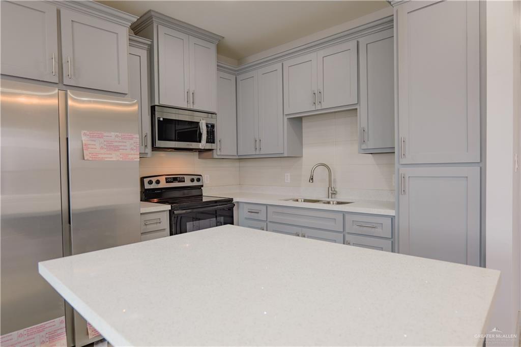 3052 Briggs Road, Unit B Weslaco, TX 78596 - Photo 11 of 12 a kitchen with kitchen island a sink appliances and cabinets