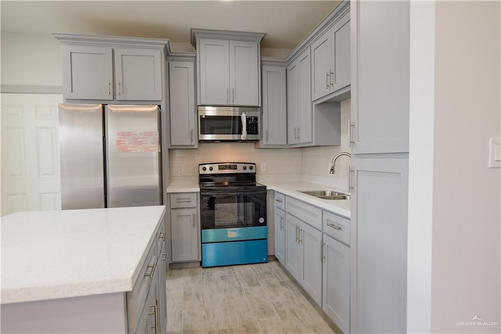 3052 Briggs Road, Unit B Weslaco, TX 78596 - Photo 12 of 12 a kitchen with stainless steel appliances a refrigerator stove microwave and sink