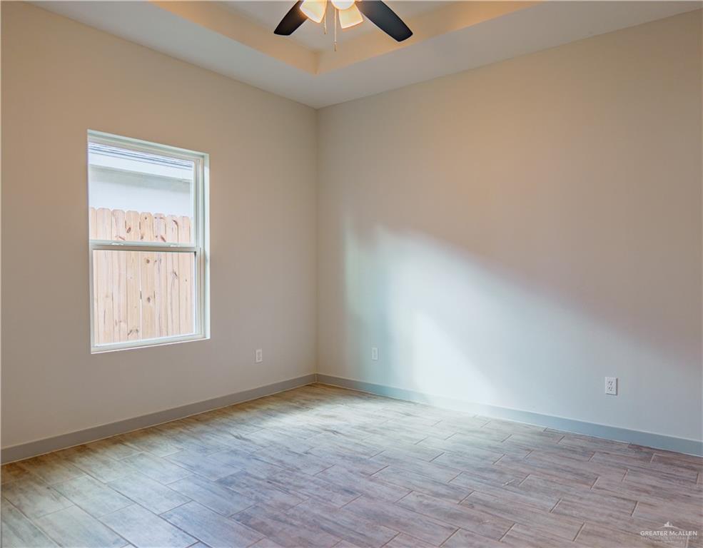 3052 Briggs Road, Unit B Weslaco, TX 78596 - Photo 8 of 12 an empty room with a window and a ceiling fan