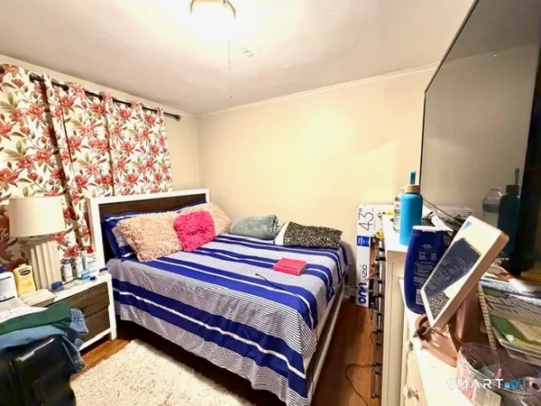 a bedroom with a bed and wooden floor