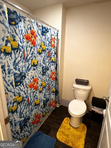 a bathroom with a toilet and a shower curtain