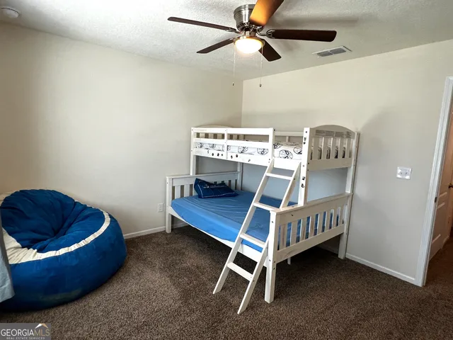 a bedroom with a bed and a chandelier fan