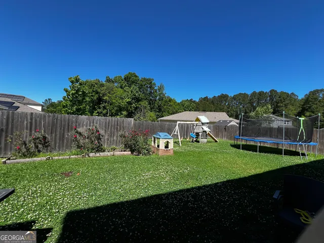 a view of a garden with a house in the background