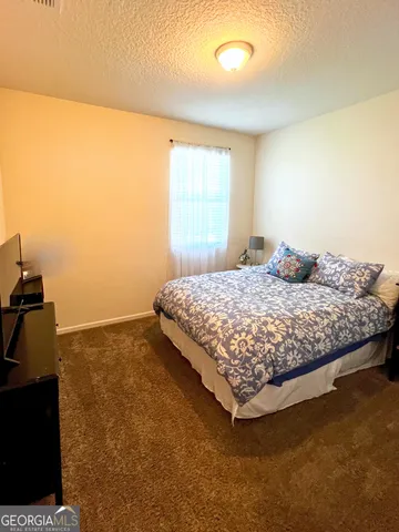 a bedroom with a bed and a night stand