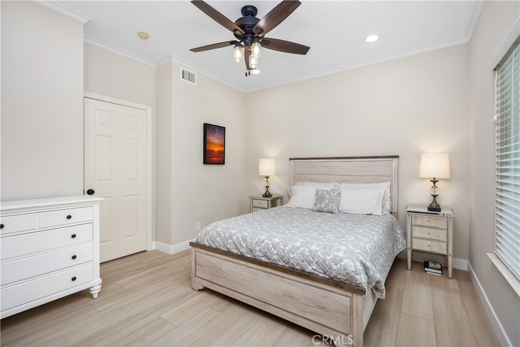 27121 Woodbluff Road Laguna Hills, CA 92653 - Photo 15 of 30 a bedroom with a bed and a chandelier