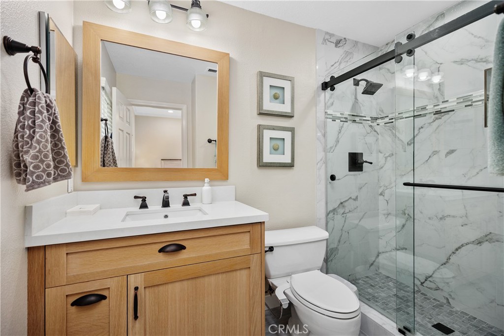 27121 Woodbluff Road Laguna Hills, CA 92653 - Photo 16 of 30 a bathroom with a sink toilet vanity and shower