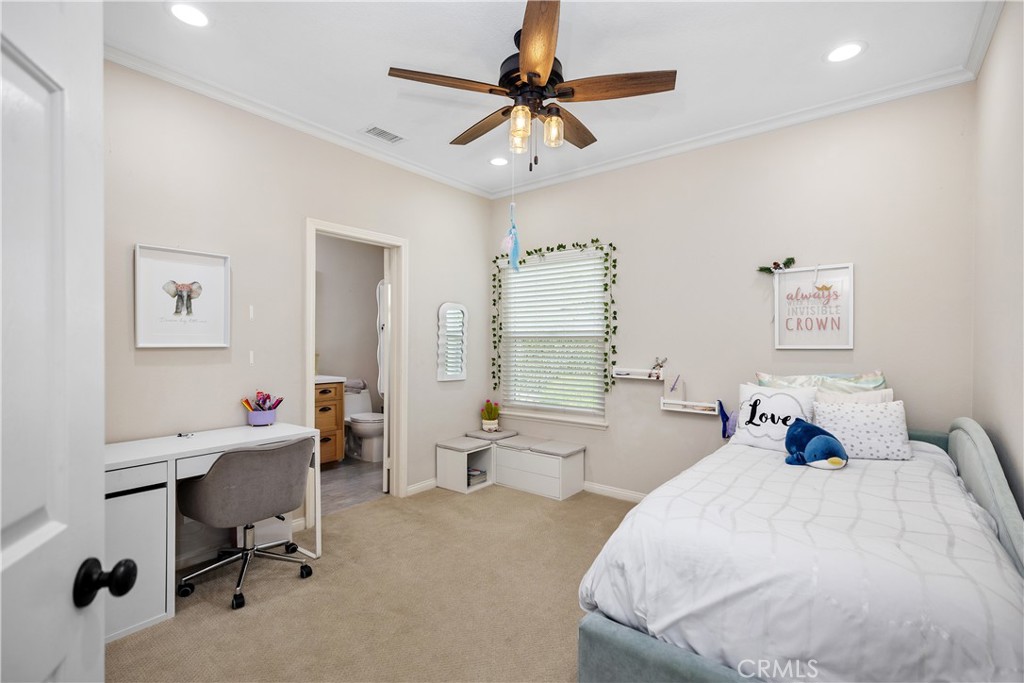 27121 Woodbluff Road Laguna Hills, CA 92653 - Photo 17 of 30 a bedroom with a bed a desk and a chandelier