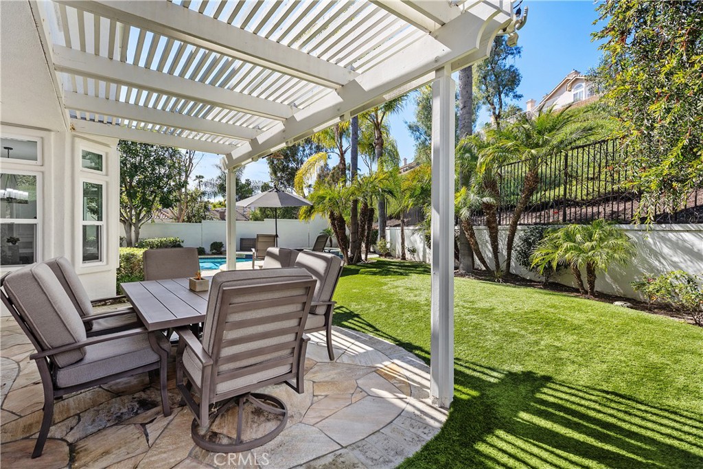 27121 Woodbluff Road Laguna Hills, CA 92653 - Photo 26 of 30 a view of a patio with table and chairs potted plants and floor to ceiling window