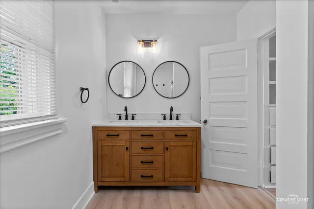 a bathroom with a double vanity sink and a window
