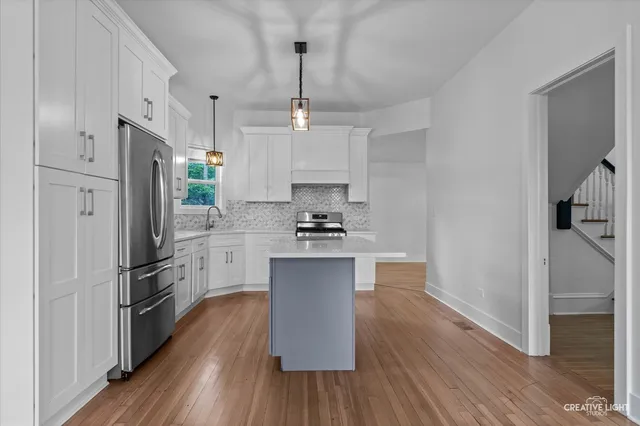 a kitchen with a refrigerator and a stove top oven