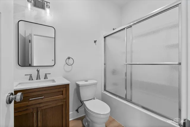 a bathroom with a toilet sink vanity and mirror