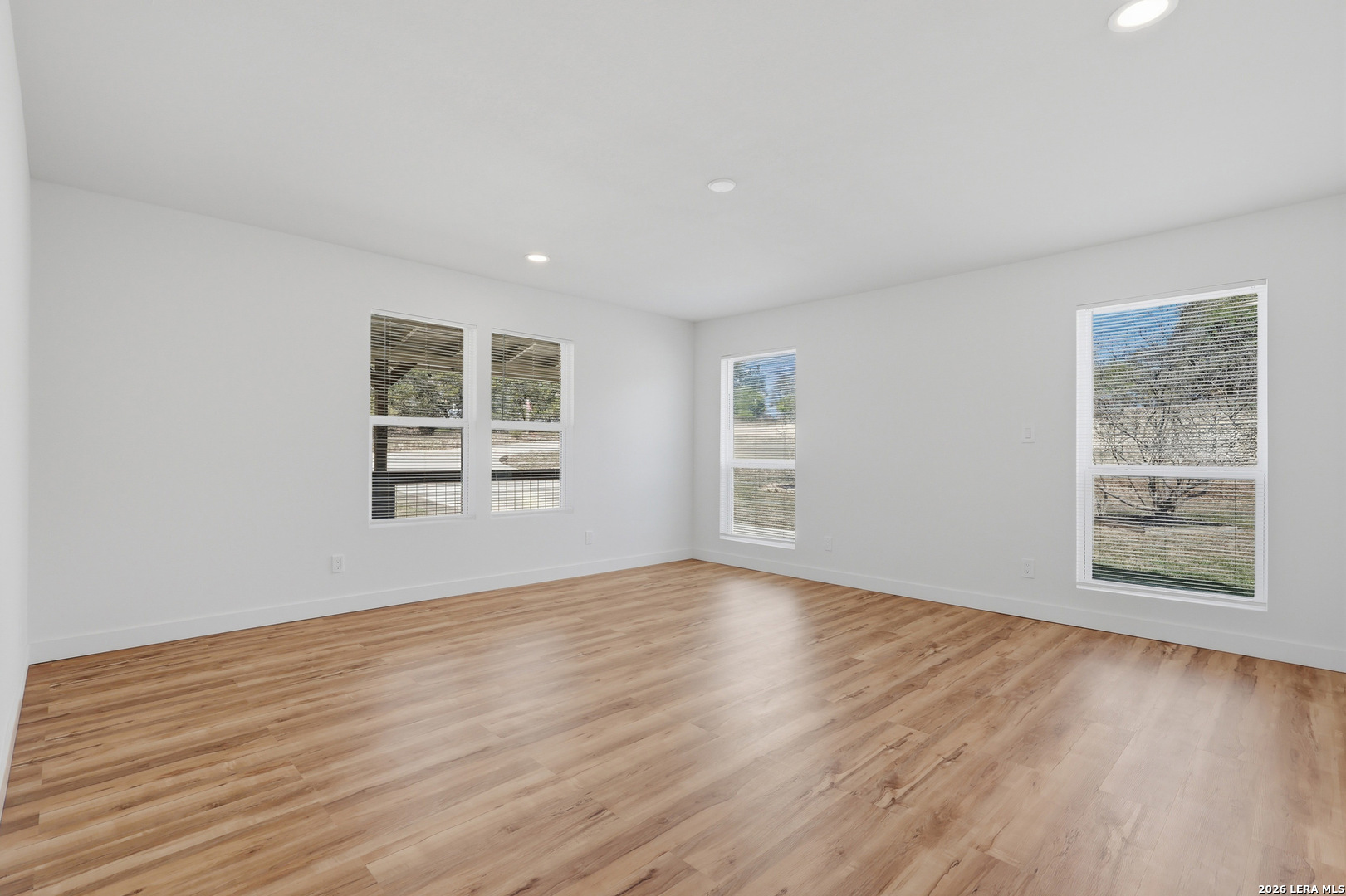 1333 Comanche Path Bandera, TX 78003 - Photo 27 of 41 a view of an empty room with wooden floor and a window