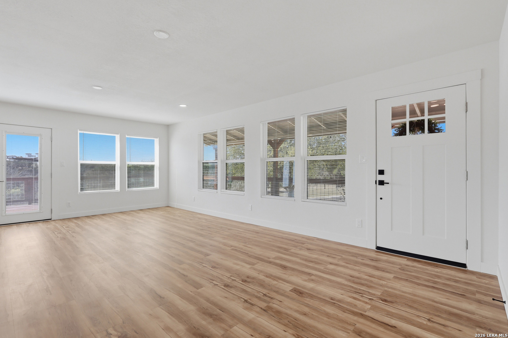 1333 Comanche Path Bandera, TX 78003 - Photo 9 of 41 a view of an empty room with wooden floor and windows