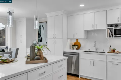 a kitchen with stainless steel appliances a refrigerator sink and white cabinets