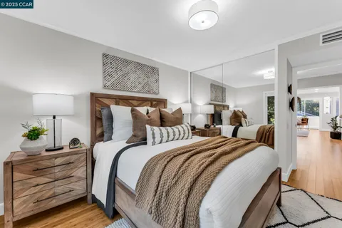 a bedroom with a bed a table and painting on the wall