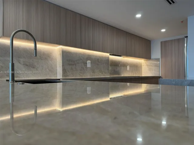 a view of a kitchen with stainless steel appliances wooden floor and a refrigerator