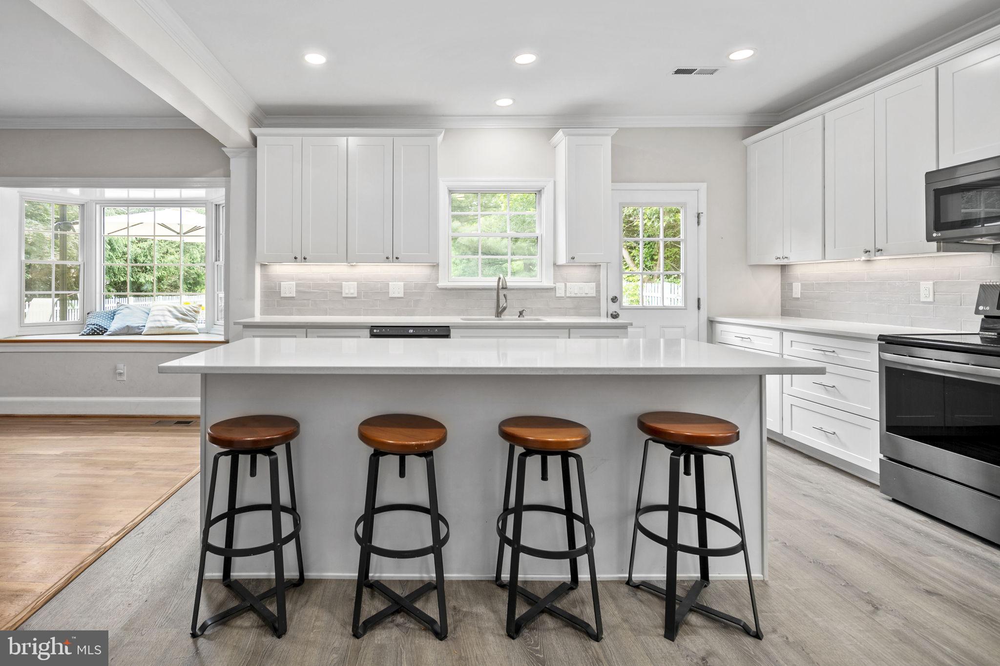 6916 Seven Locks Road Cabin John, MD 20818 - Photo 18 of 38 a kitchen with stainless steel appliances granite countertop table chairs sink and cabinets