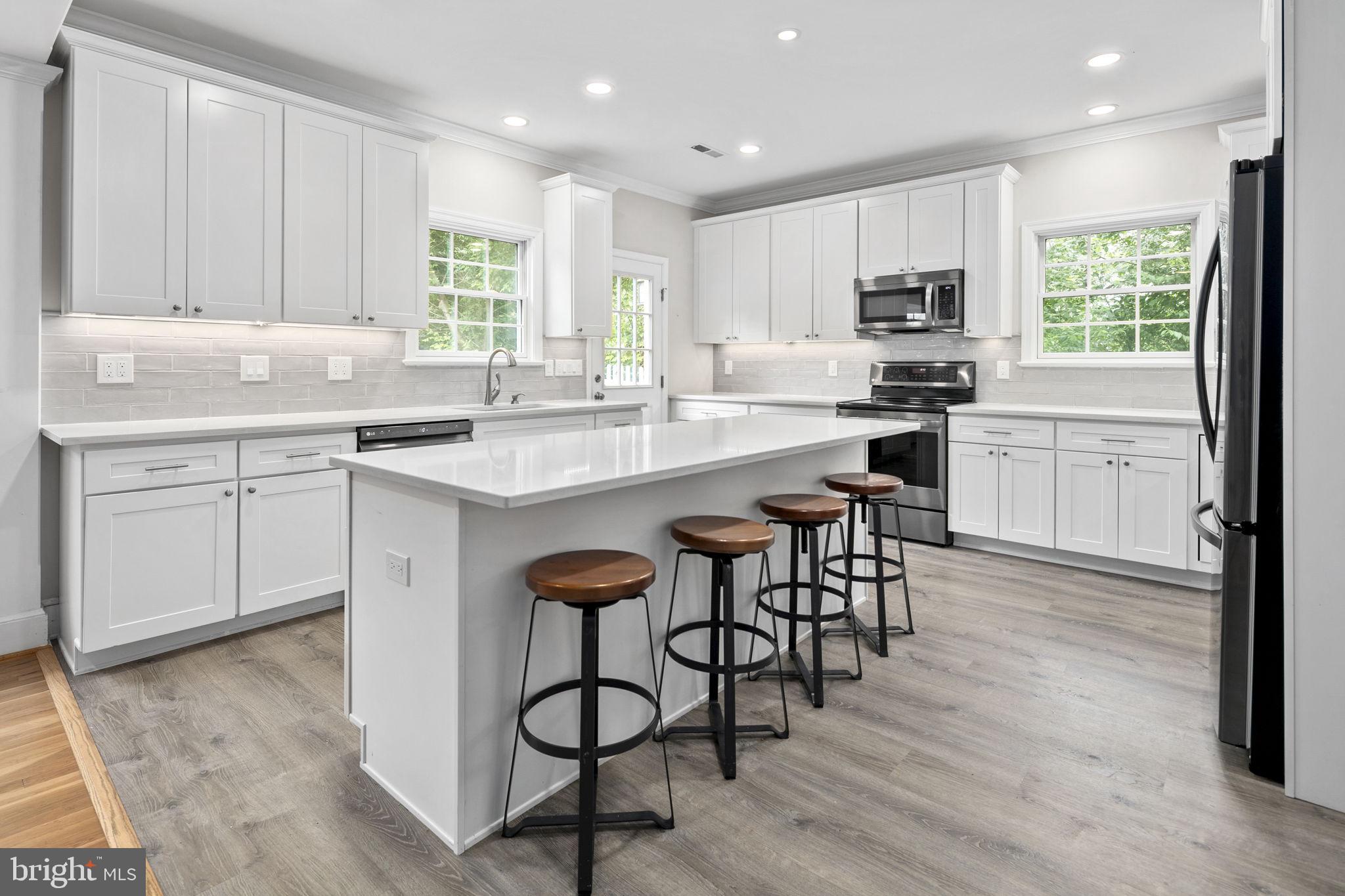 6916 Seven Locks Road Cabin John, MD 20818 - Photo 2 of 38 a kitchen with stainless steel appliances granite countertop white cabinets a table and chairs