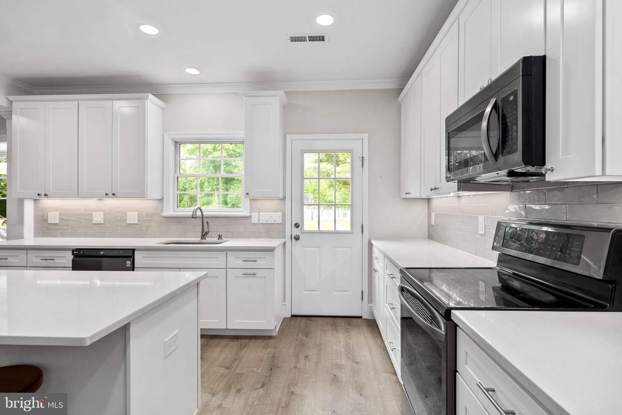 6916 Seven Locks Road Cabin John, MD 20818 - Photo 21 of 38 a kitchen with a sink stove and microwave