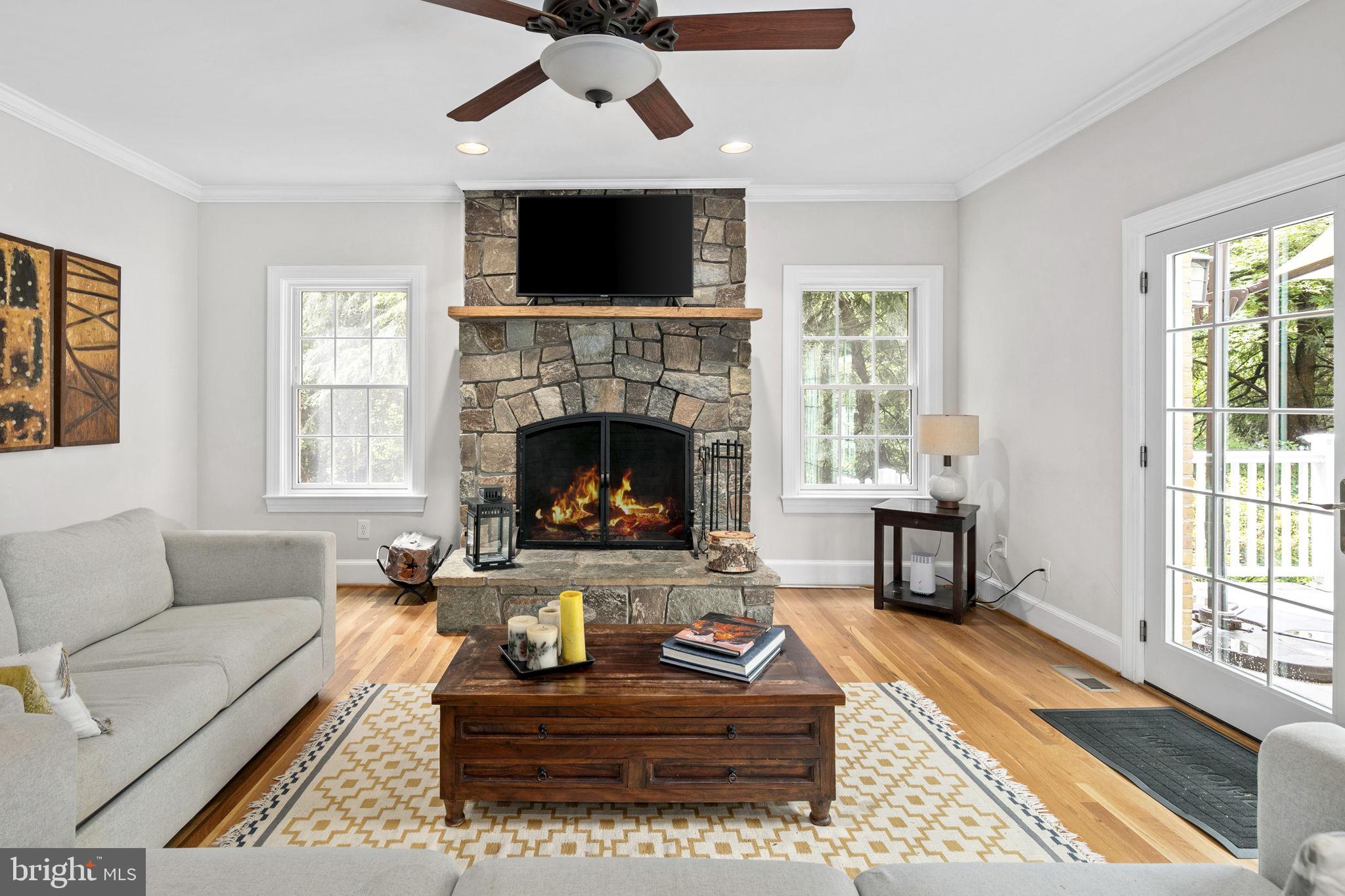 6916 Seven Locks Road Cabin John, MD 20818 - Photo 8 of 38 a living room with furniture a flat screen tv and a fireplace