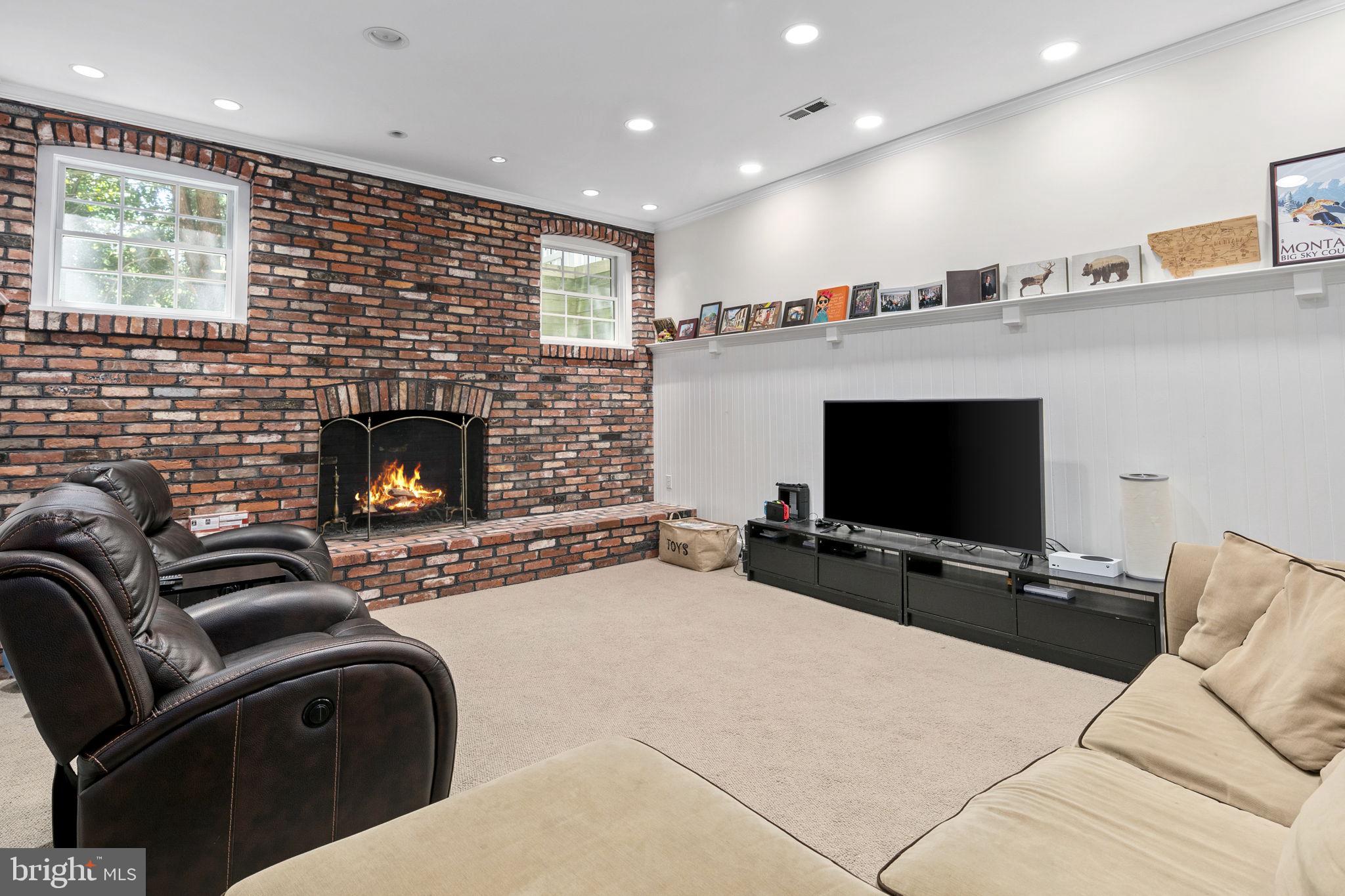 6916 Seven Locks Road Cabin John, MD 20818 - Photo 10 of 38 a living room with furniture flat screen tv and a fireplace