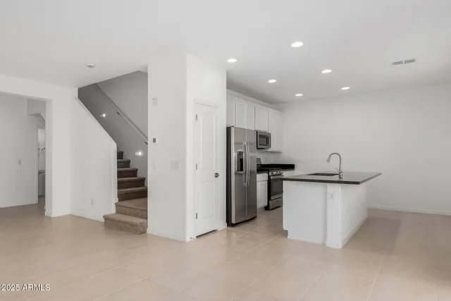 a kitchen with stainless steel appliances granite countertop a sink and a refrigerator