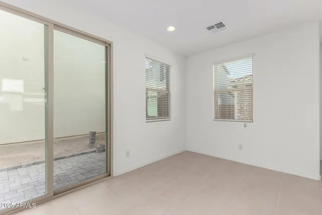 an empty room with a kitchen and stainless steel appliances