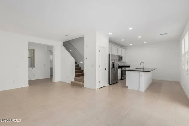 a view of a kitchen with stainless steel appliances kitchen island a refrigerator oven a sink and a stove